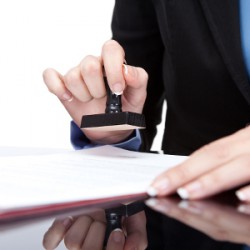 belofloripa-registration-certificates-450x300 Stamping hand - Young businesswoman (or notary public) seating at the desk in office and stamping document